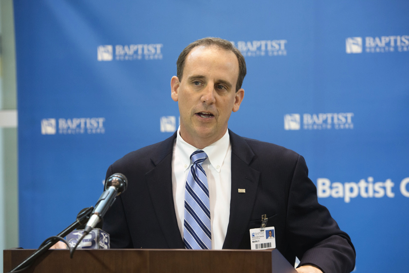 Mark Faulkner CEO of Baptist Health Care at podium announcing Baptist and Mayo teaming together.