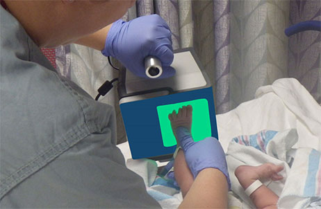 Medical team member scanning newborn foot